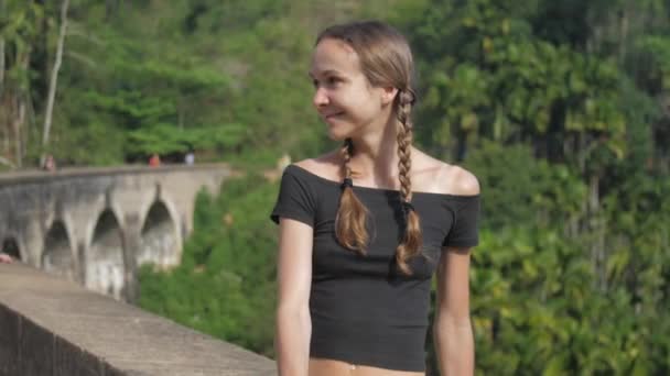 Vrouw zit op beroemde brug en geniet van wilde tropische natuur — Stockvideo