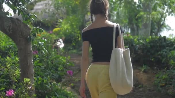 Junge Frau in gelb-schwarzer Kleidung dreht sich um und geht — Stockvideo