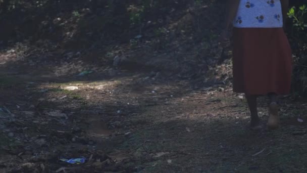 Woman with machete walks along dirty shady road slow motion — Stock Video