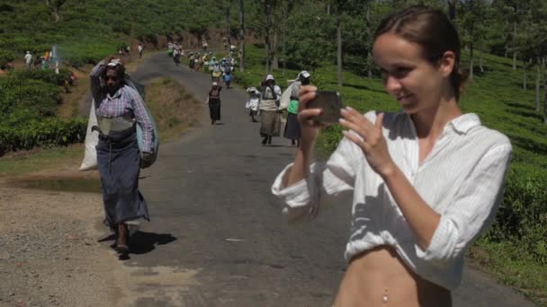 Dame in shirt maakt foto 's van werknemers op theeplantages — Stockvideo