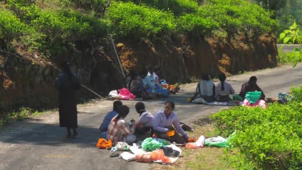 Travailleurs locaux plantations de thé se détendre assis sur la route grise — Video