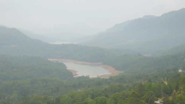 Lago azul tranquilo pictórico rodeado de densos bosques verdes — Vídeo de stock