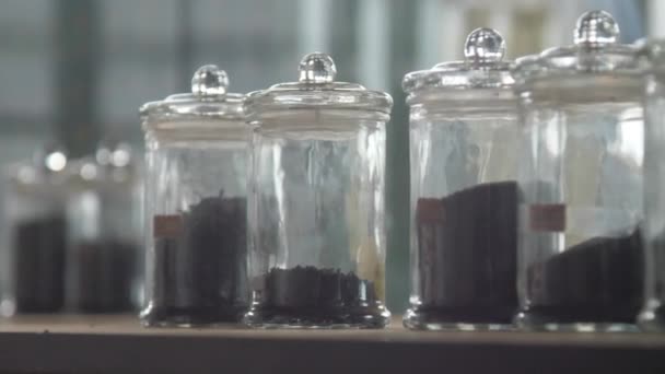 Рука людини бере прозорі пляшки з сортами чаю — стокове відео