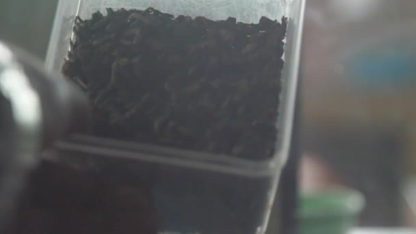 sortes de thé marquées dans des bouteilles en verre transparent sur table noire 