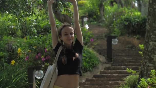 Señora delgada se estira con sonrisa alegre de pie en las escaleras — Vídeo de stock