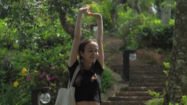 Slim lady stretches with cheerful smile standing on stairs — 비디오