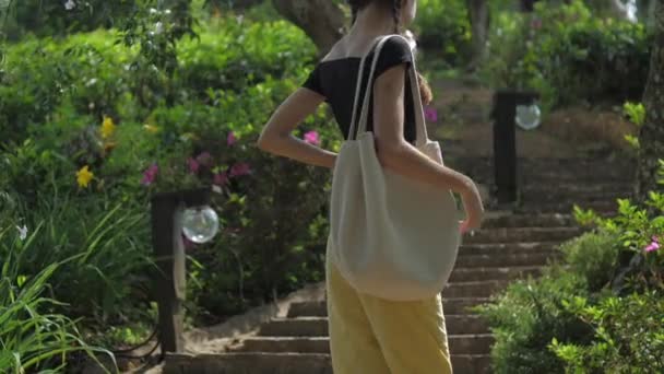 Jonge vrouw in geel en zwart dressing draait en loopt — Stockvideo