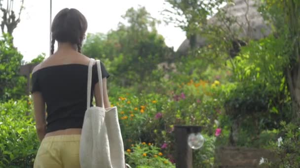 Jovem mulher em curativo amarelo e preto vira e caminha — Vídeo de Stock