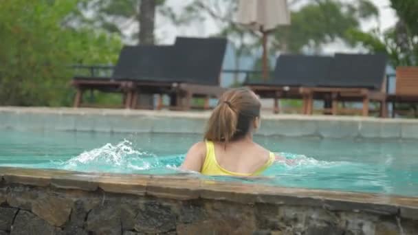 Young woman with ponytail swims in brown swimming pool — 비디오