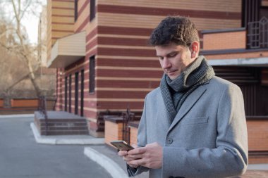 Yetişkin adam şehirde akıllı telefon kullanıyor.