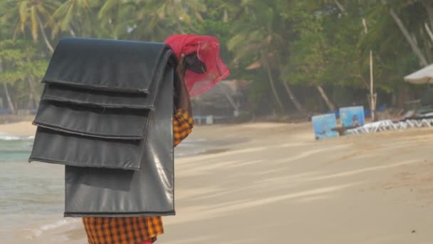 Singhalesischer Mann läuft mit Matten am gelben Sandstrand entlang — Stockvideo
