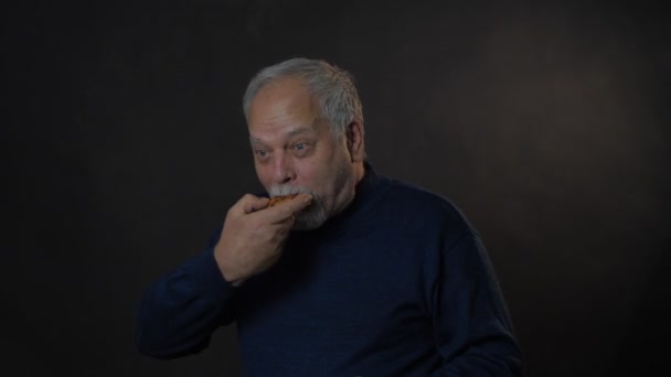 在灰色工作室背景下吃披萨的老人 — 图库视频影像