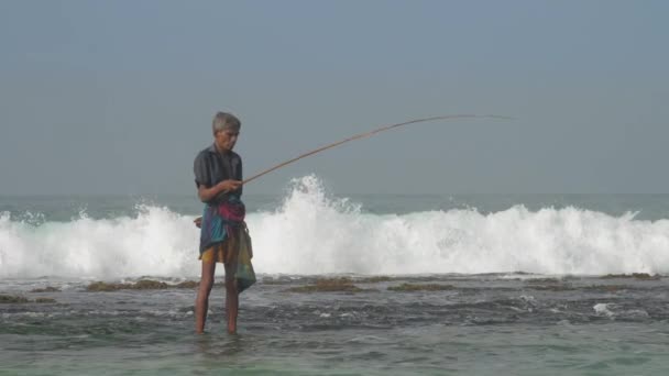 Sinhalese muž chytí ryby a vloží do speciální tašky — Stock video
