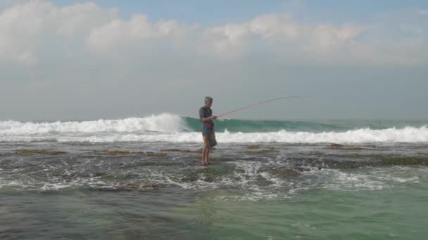 Silueta de pescador envejecido se encuentra en aguas profundas del océano azul — Vídeos de Stock