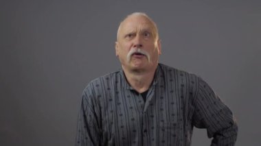 Stüdyoda poz veren Avrupalı olgun bir adam karanlık arka planda izole edilmiş