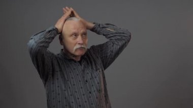 Stüdyodaki ciddi Avrupalı olgun adam karanlık arka planda izole edilmiş.