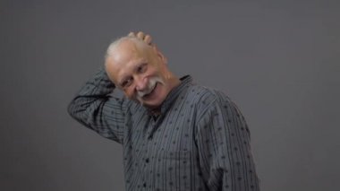 Stüdyodaki düşünceli Avrupalı olgun adam karanlık arka planda izole edilmiş.