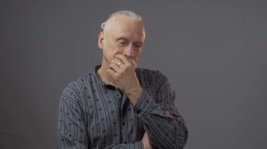 Stüdyodaki düşünceli Avrupalı olgun adam karanlık arka planda izole edilmiş.