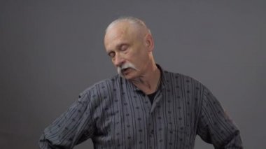 Stüdyoda poz veren Avrupalı olgun bir adam karanlık arka planda izole edilmiş