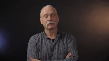 Stüdyoda poz veren Avrupalı olgun bir adam karanlık arka planda izole edilmiş