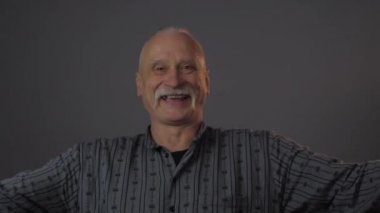 Stüdyoda, karanlık arka planda izole edilmiş mutlu Avrupalı olgun bir adam.