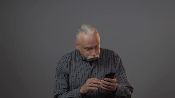 Ευρωπαίος Ώριμος Άντρας Που Χρησιμοποιεί Smartphone Στούντιο Απομονωμένο Σκοτεινό Φόντο — Αρχείο Βίντεο