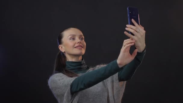 Ευρωπαία Ενήλικη Γυναίκα Βγάζει Selfie Στο Smartphone Στούντιο Απομονωμένο Σκούρο — Αρχείο Βίντεο