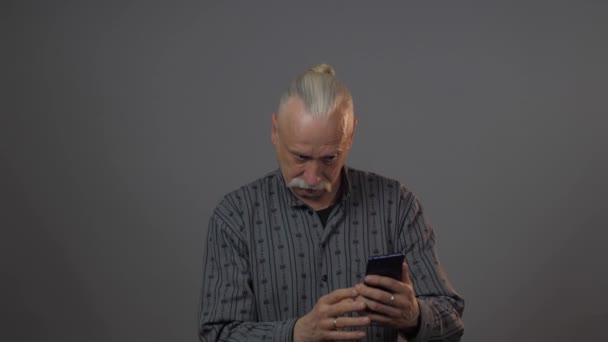 Ευρωπαίος Ώριμος Άντρας Που Χρησιμοποιεί Smartphone Στούντιο Απομονωμένο Σκοτεινό Φόντο — Αρχείο Βίντεο