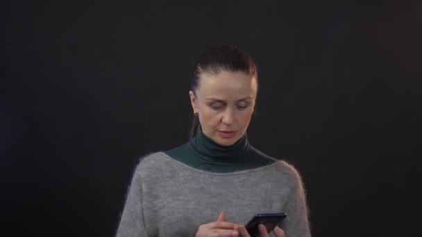 Mulher Adulta Europeia Usa Smartphone Estúdio Isolado Fundo Escuro — Vídeo de Stock