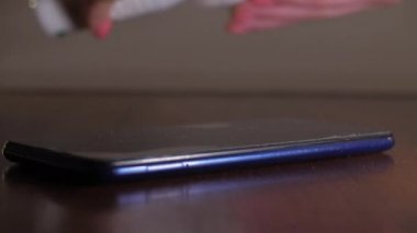 Antiseptikle akıllı telefona muhalif olan birinin yakın plan fotoğrafı.