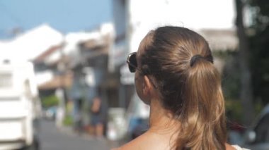 Avrupalı bir kız Sri Lanka 'da sessiz bir caddede yürüyor, ağır çekimde. Kasaba çevresindeki turizm kavramı