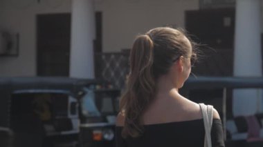 Avrupalı bir kız Sri Lanka 'da sessiz bir caddede yürüyor, ağır çekimde. Kasaba çevresindeki turizm kavramı