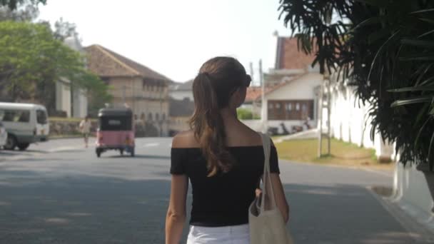 ヨーロッパの女の子は スリランカ スローモーションの熱帯都市の静かな通りに沿って歩いている 町の環境における観光の概念 — ストック動画