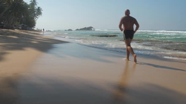 Europejski Dorosły Mężczyzna Jogging Piaszczystym Wybrzeżu Plaży Pobliżu Oceanu Falami — Wideo stockowe