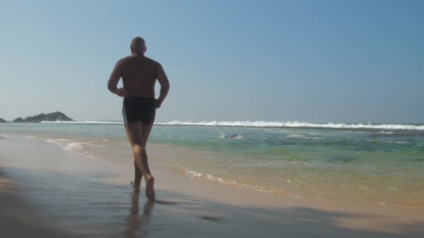 Europäischer Erwachsener Mann Joggt Sandstränden Der Nähe Des Ozeans Mit — Stockvideo