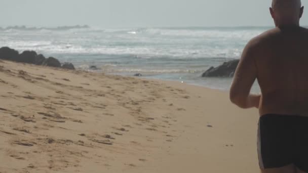 Європейський Дорослий Чоловік Біжить Піщаному Узбережжі Біля Океану Хвилями Сонячний — стокове відео