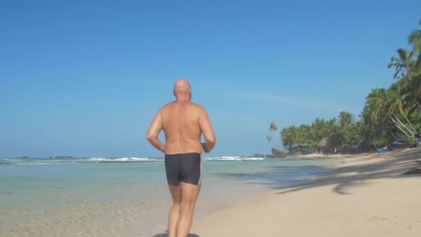 European Adult Man Jogging Sandy Beach Coast Ocean Waves Sunny — Stock Video