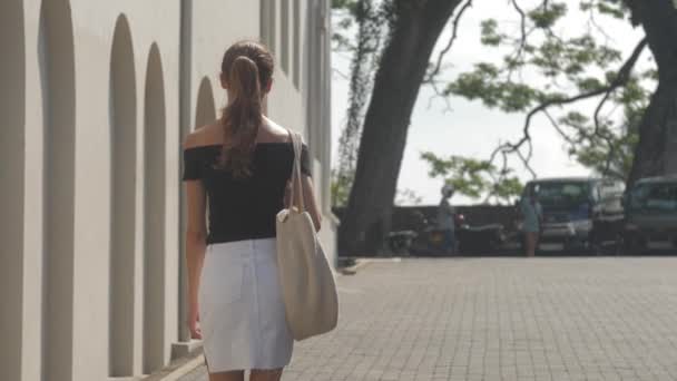 欧洲女孩正沿着斯里兰卡热带城市安静的街道走着 动作缓慢 城市环境中的旅游概念 — 图库视频影像