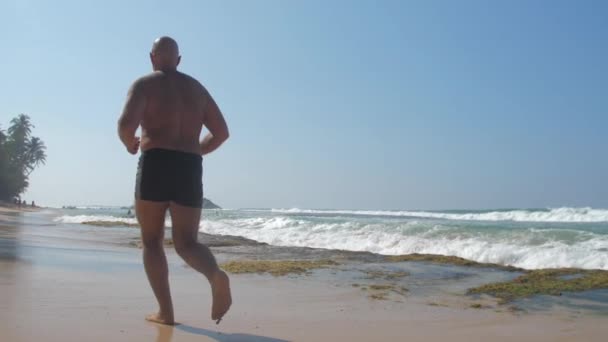 Europese Volwassen Man Joggen Zandstrand Kust Buurt Van Oceaan Met — Stockvideo