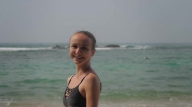 Sınırsız okyanusa karşı sahilde yürüyen mutlu bir turist.