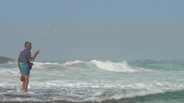 Pescador envelhecido verifica poste de pesca de madeira na água — Vídeo de Stock