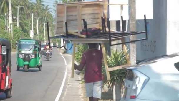 Lokale man werkt hard met zware houten meubels — Stockvideo