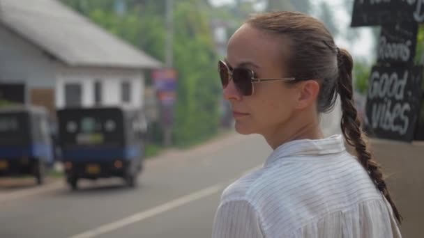 Fille promenades touristiques le long de la route de rue contre la nature tropicale — Video