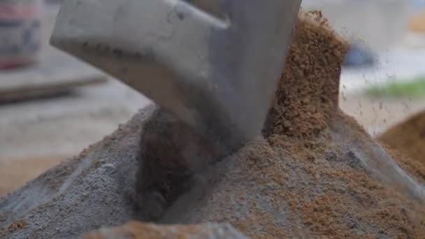 Lokale man dekt geel zand stapel met cement sluiten — Stockvideo