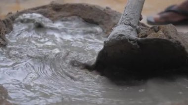 İnşaat işçisi su küreğiyle çimentoyu karıştırdı