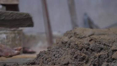 Profesyonel inşaat işçisi ıslak gri çimentoyu karıştırıyor
