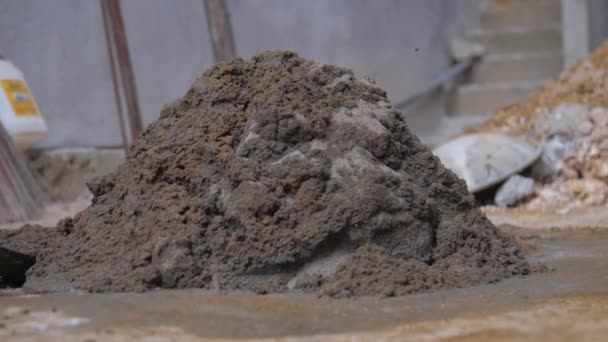 Persoon mengt natte cement met metalen schop op de grond — Stockvideo