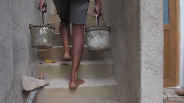 Gars local recueille ciment gris dans le panier sur la construction — Video