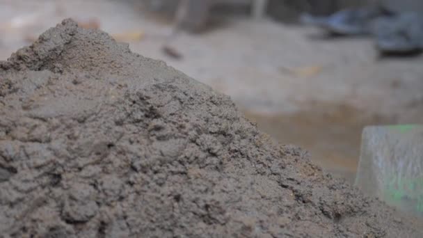 Trabalhador da construção mistura cimento cinza molhado segurando pá — Vídeo de Stock