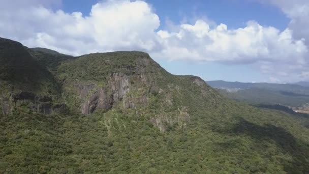 Βουνό με πλούσια χλωρίδα κοντά σε μικρή χώρα ενάντια στον ουρανό — Αρχείο Βίντεο